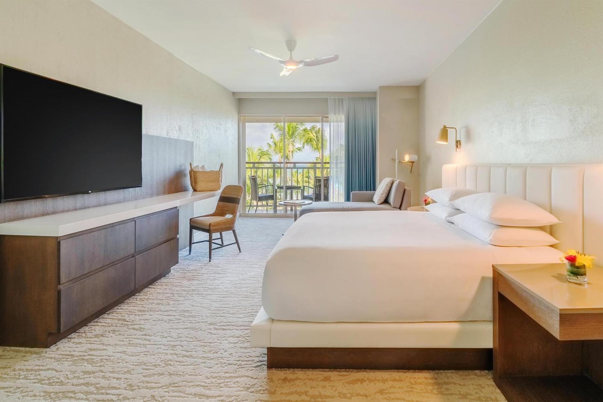 Zimmer mit Kingsize-Bett, Balkon und Blick auf das Resort