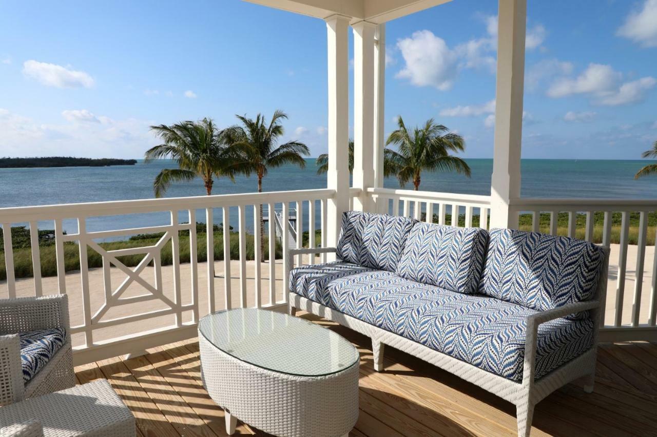 Suite de 1 dormitorio con cama grande, balcón frente al mar y zona de cocina